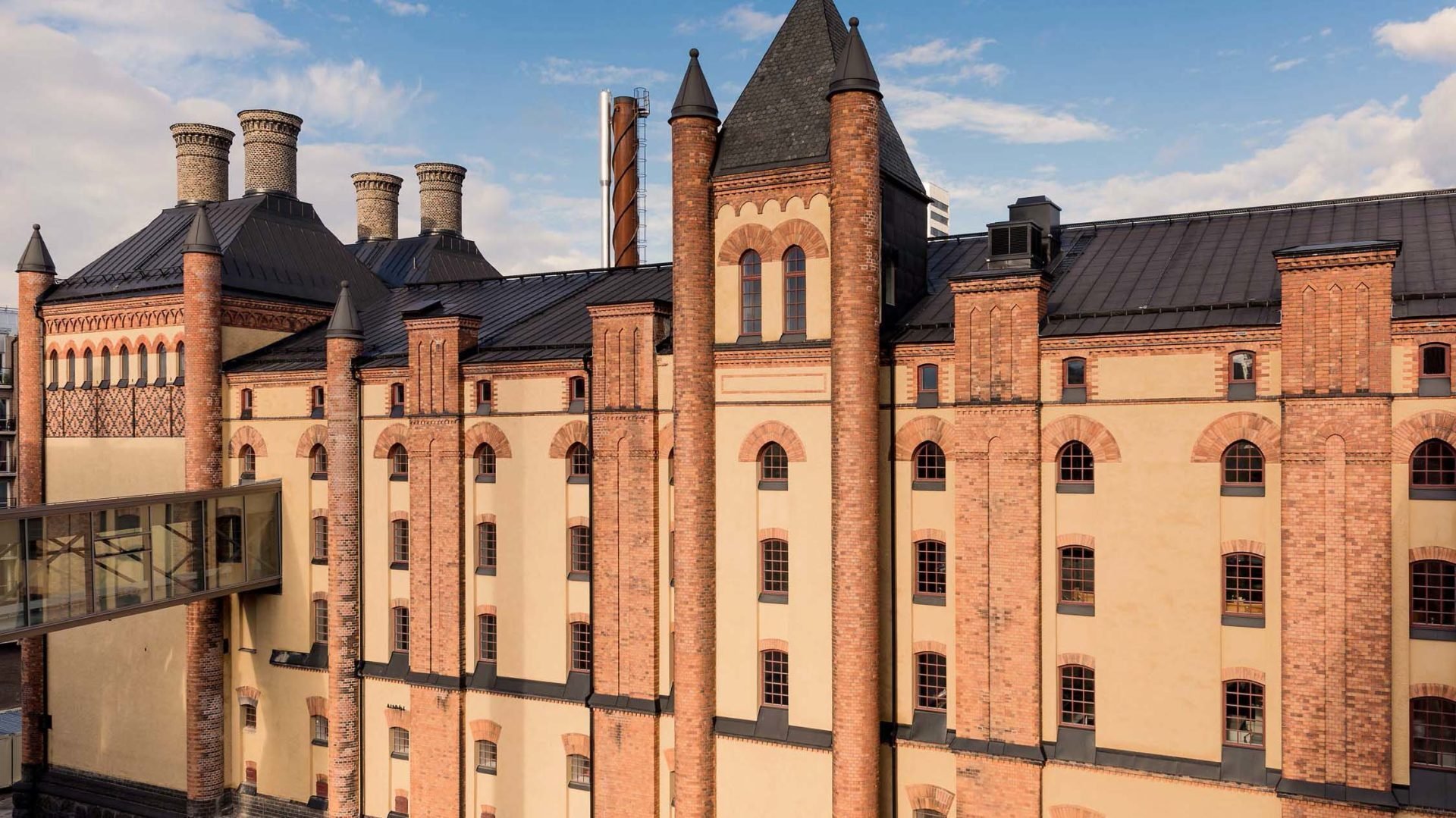 Fastigheten Stora Bryggeriet i ljus pust och tegel och svart tak med kulturhistorisk klassificering som varsamt renoverats